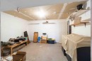 Versatile interior space featuring a concrete floor, white walls, overhead lighting, and built-in shelving