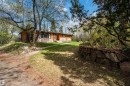 Ranch-style residence featuring wood siding and a stone foundation