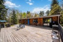 Expansive exterior deck featuring natural wood planks and a black metal railing
