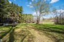 Expansive outdoor grounds featuring a large grassy area, mature trees, and natural landscaping