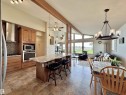 Open-concept living space featuring a kitchen with wood cabinetry, granite-finish countertops, and stainless steel appliances