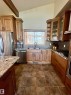 Kitchen featuring vaulted ceilings with exposed beams, stainless steel appliances, granite countertops, and tile flooring
