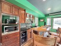 Entertainment space featuring a custom wood-finish bar with seating, recessed lighting, and large windows