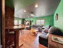 Spacious recreation room featuring wood-finish flooring, recessed lighting, and a built-in projector