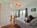 Bedroom featuring wood-finish flooring, a ceiling fan, and a large sliding glass door