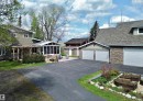 Paved driveway providing access to a three-car garage with stone veneer accents and a separate single-car garage