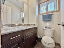 Bathroom featuring a dark wood-finish vanity with chrome hardware, a light-colored countertop, and a tiled backsplash