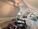 Spacious attic bonus room featuring wood-finish flooring and ample natural light from multiple windows