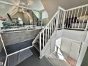 Multi-level interior featuring a white painted staircase with traditional spindles and paneling