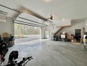 Spacious garage featuring a concrete floor, overhead lighting, and an automatic garage door opener