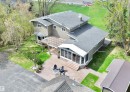 Two-story residence featuring a gray shingle roof, neutral-toned siding, and multiple windows
