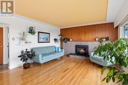 Bright living room with efficient gas fireplace insert and wood panelled wall