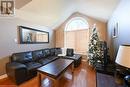 Living room featuring wood-type flooring, a textured ceiling, and vaulted ceiling