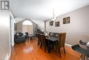 Dining space featuring a textured ceiling, an inviting chandelier, hardwood / wood-style flooring, and vaulted ceiling