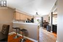 Kitchen featuring ceiling fan, light brown cabinets, light hardwood / wood-style floors, decorative backsplash, and appliances with stainless steel finishes