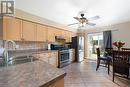 Kitchen with decorative backsplash, appliances with stainless steel finishes, sink, light brown cabinets, and light tile patterned floors