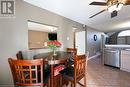 Tiled dining room with ceiling fan and sink