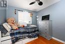 Bedroom with ceiling fan, hardwood / wood-style floors, and a textured ceiling