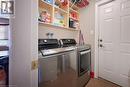 Laundry area with washer and clothes dryer and light tile patterned floors