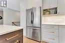Kitchen with decorative backsplash, stainless steel refrigerator, and light wood-type flooring