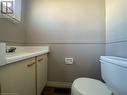 Half bath featuring toilet, vanity, a skylight, and visible vents
