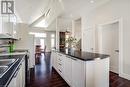Kitchen featuring white appliances, dark countertops, dark wood-style floors, and ceiling fan