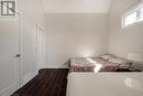 Bedroom featuring vaulted ceiling, wood finished floors, and baseboards