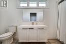 Bathroom featuring baseboards, wood finished floors, toilet, and vanity