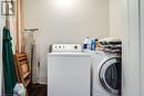 Clothes washing area with independent washer and dryer and wood finished floors