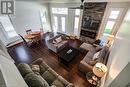Living area with ceiling fan, healthy amount of natural light, a fireplace, and hardwood / wood-style flooring
