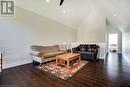 Living area featuring lofted ceiling, wood finished floors, baseboards, and a ceiling fan