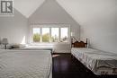 Bedroom with vaulted ceiling, dark wood-style floors, and baseboards