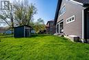 View of green lawn with a shed and an outdoor structure