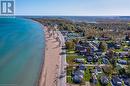 Aerial view of property and surrounding area with waterfront with a beach and nearby suburban area