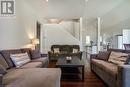 Living room with lofted ceiling, dark wood-style floors, stairs, and recessed lighting