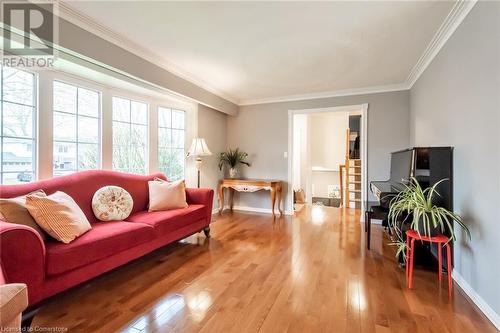 Living area with light wood finished floors, crown molding, and baseboards