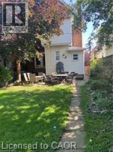 Rear view of property featuring a yard, a chimney, and a patio