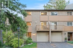 View of front facade with a balcony, driveway, and a garage