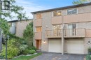 View of front facade featuring a balcony, driveway, and an attached garage