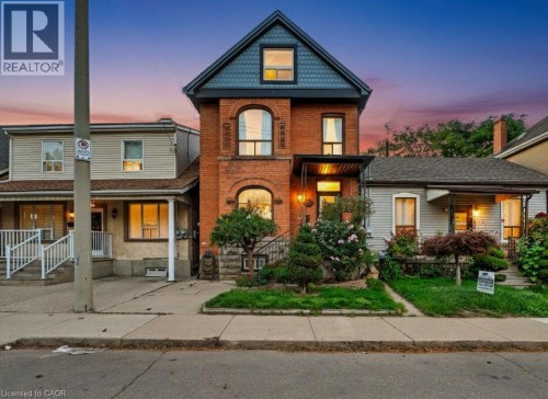 Victorian home featuring brick siding and a porch