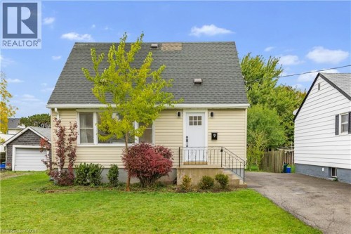Cape cod home with roof with shingles and a front lawn