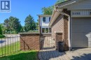 View of side of home with a gate and brick siding