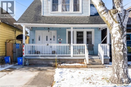 Blue siding exterior featuring a covered front porch with white railings and steps