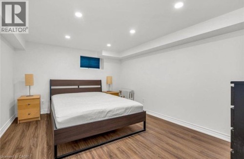 Bedroom with recessed lighting, radiator heating unit, and wood finished floors