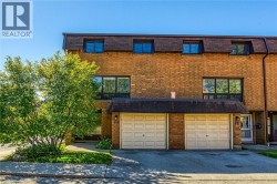 View of front facade with brick siding, an attached garage, and driveway