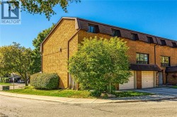 View of property with an attached garage and asphalt driveway