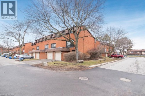 View of side of home with an attached garage, brick siding, and driveway