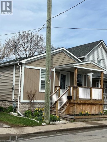 Bungalow-style residence featuring tan siding and white trim