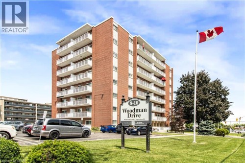 Red brick exterior building featuring multiple levels of private balconies with white railings