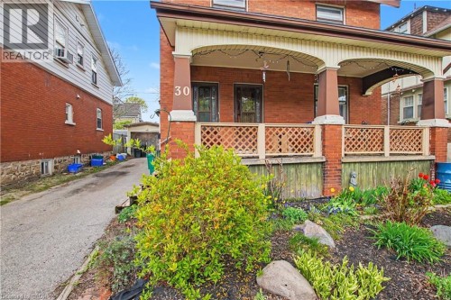 Brick facade featuring a covered front porch with arched details and decorative lattice railing